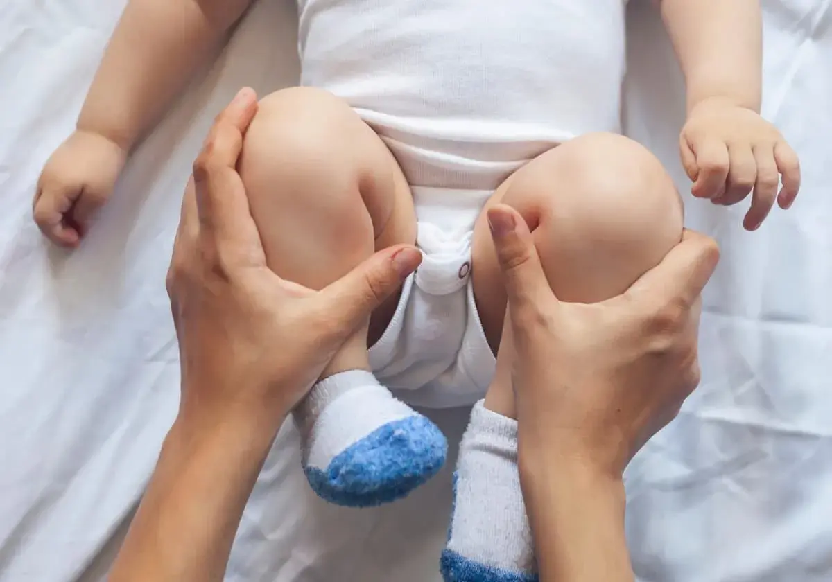 Försiktig massage av bebisens ben för att hjälpa till att få bebis att bajsa.