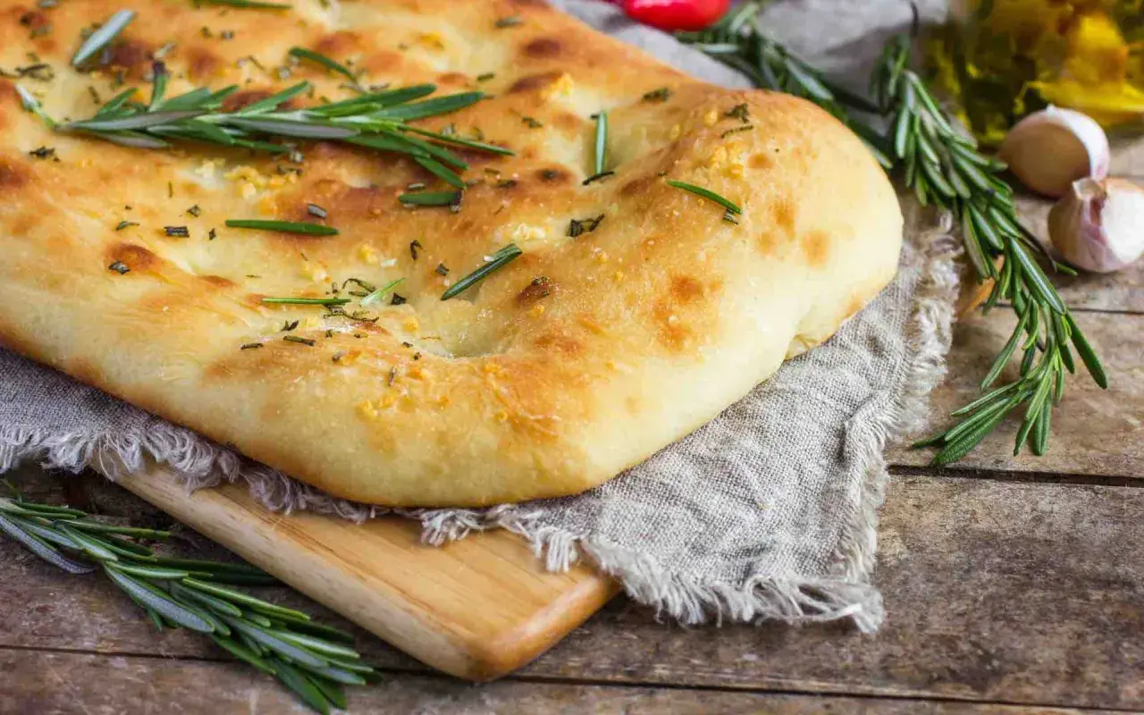 Un pain italien traditionnel, doré et moelleux, garni de romarin frais et d'ail. Parfait pour accompagner un repas.