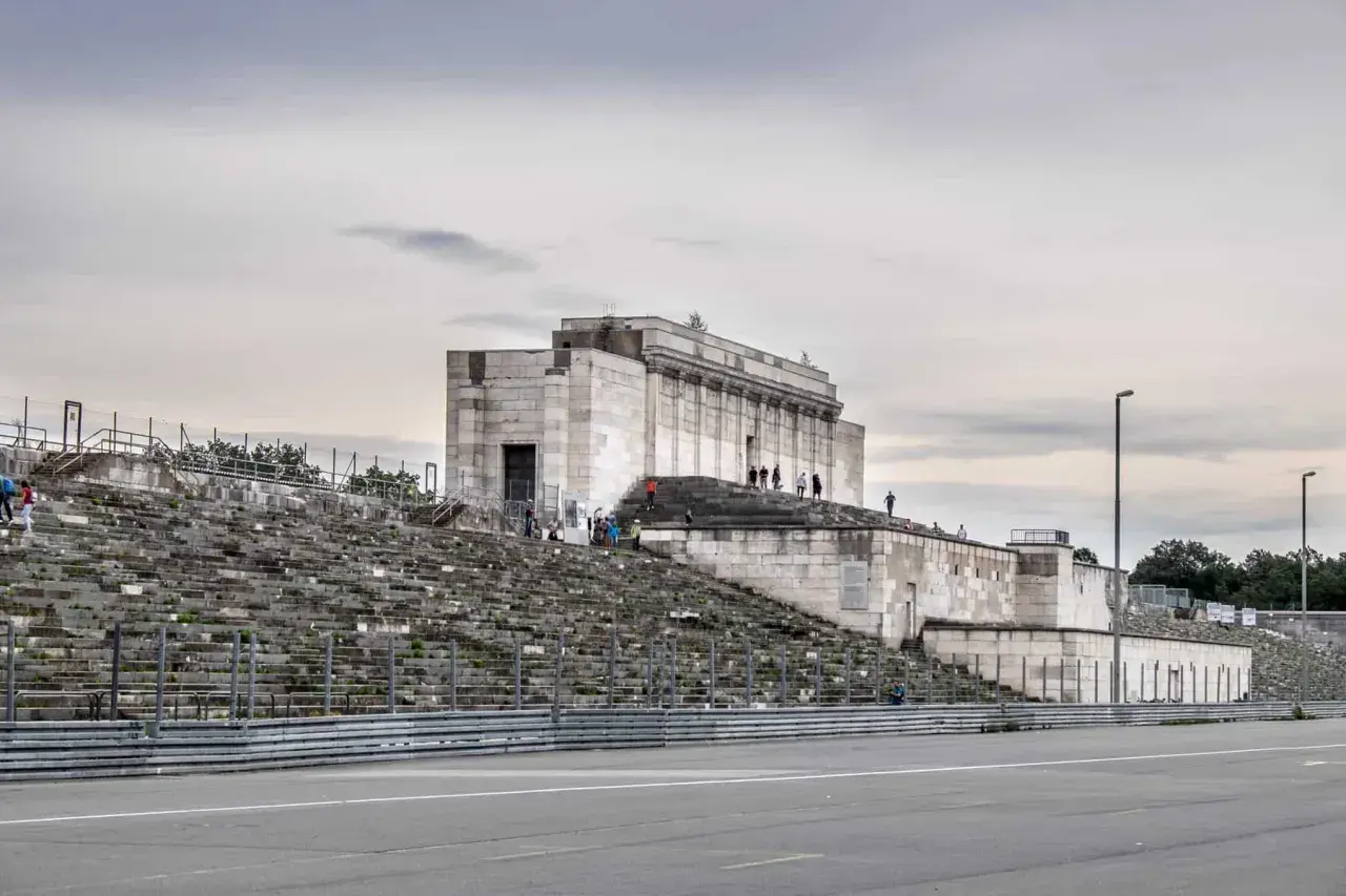 Besucher erkunden die imposanten Steintribünen und das monumentale Gebäude der Nürnberger Reichsparteitagsgelände.