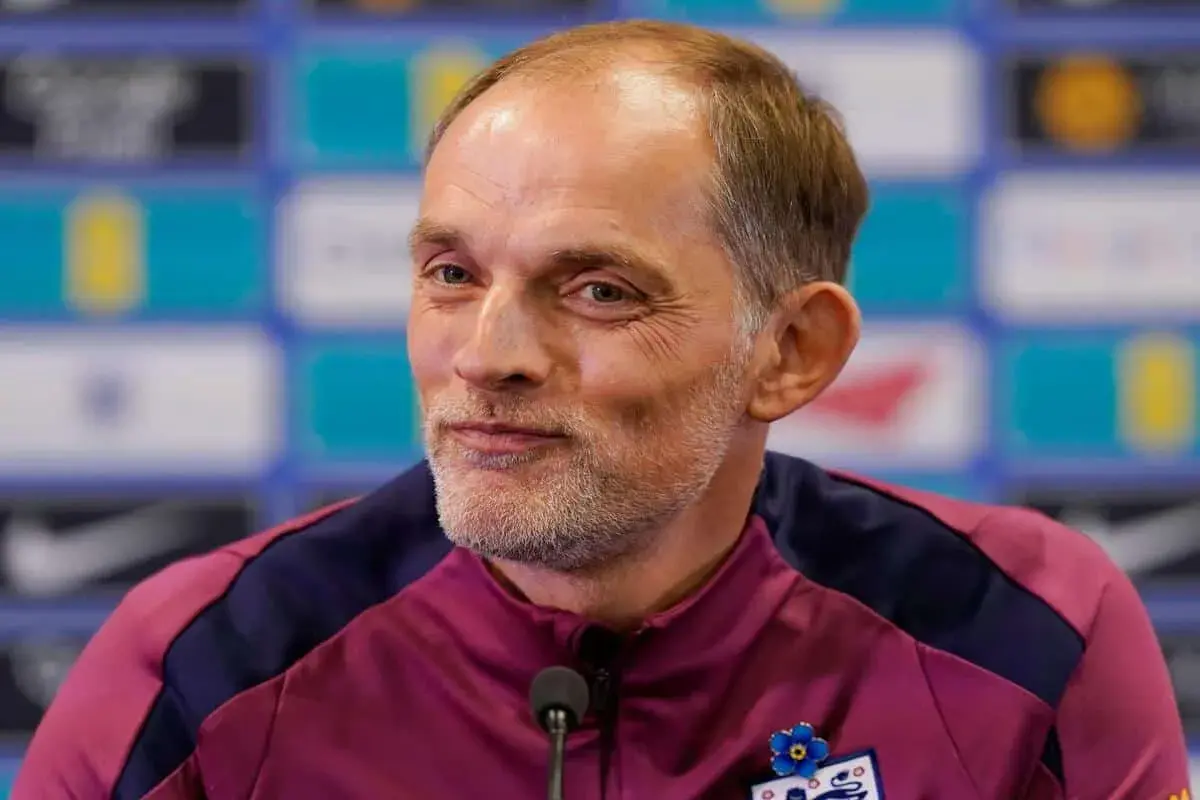 Thomas Tuchel, były trener Chelsea, w bordowej kurtce z niebieskimi wstawkami, z przypinką w kształcie niebieskiego kwiatka.