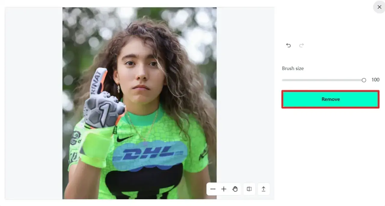Jeune gardienne de but avec un gant, prête à enlever logo sur son maillot vert fluo.