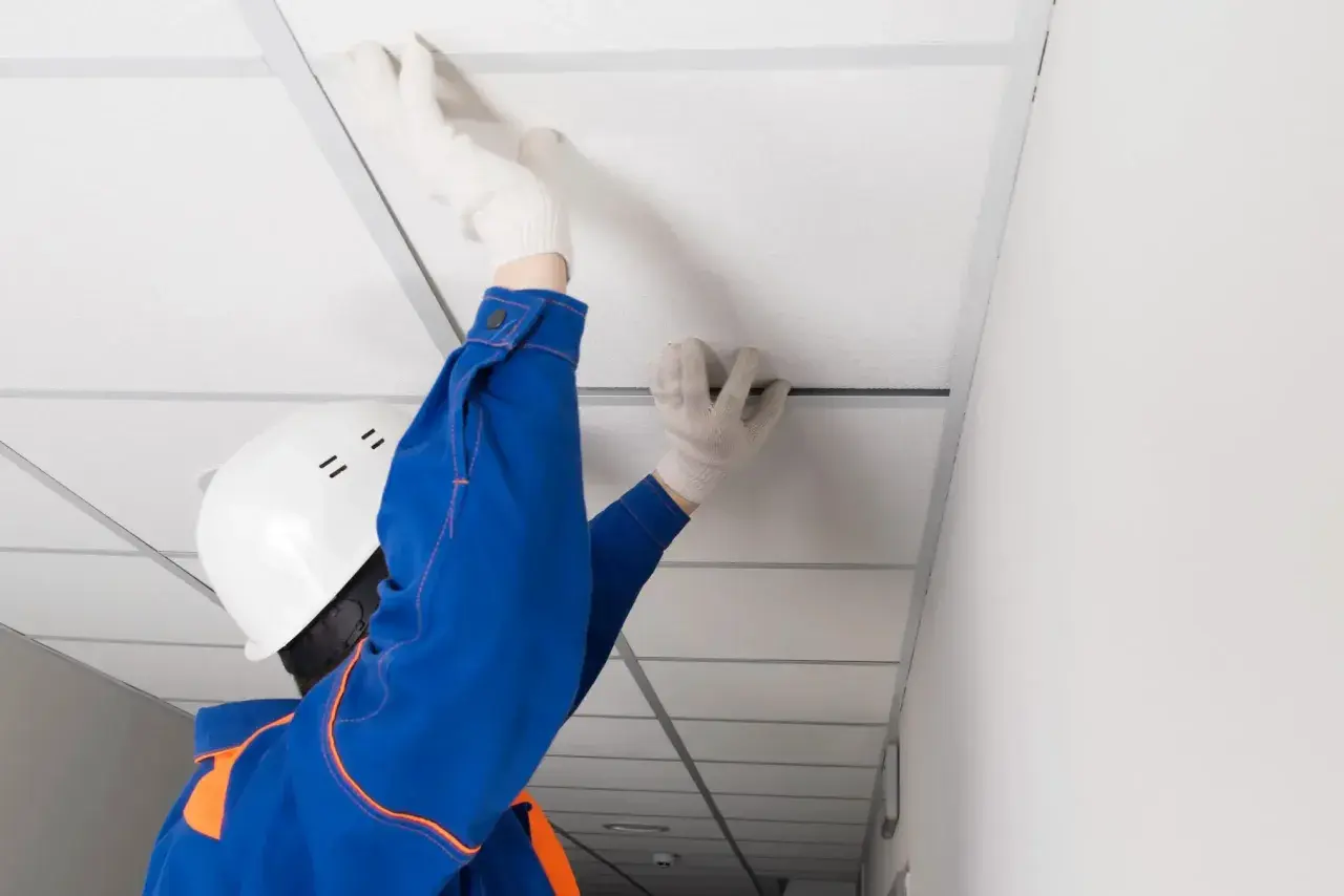 Pose d'un faux plafond dans un garage, améliorant l'isolation et l'esthétique.