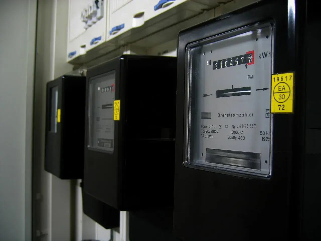 Trzy liczniki energii elektrycznej, jeden z nich pokazuje 3104572 kWh.