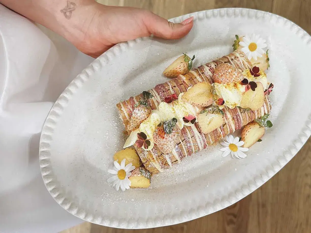 En vacker Budapestrulle med jordgubbar och blommor. Ett perfekt recept för en festlig fika!