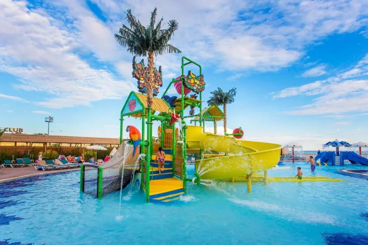 Kolorowy aquapark z palmami i zjeżdżalniami, idealne miejsce na wakacje w Eftalia. Dzieci bawią się w wodzie.