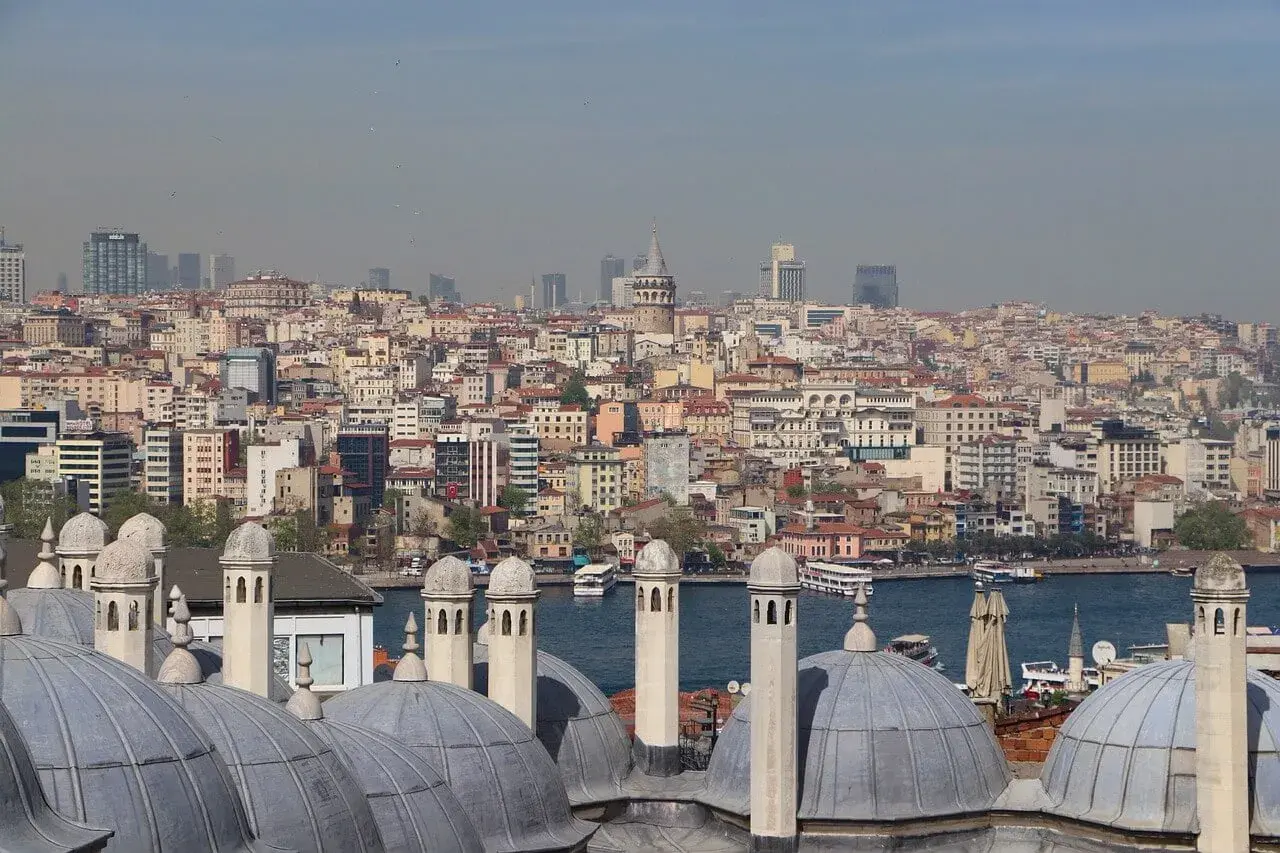 Widok na rozległe dzielnice Stambułu, z dominującą wieżą Galata i licznymi kopułami w pierwszym planie.
