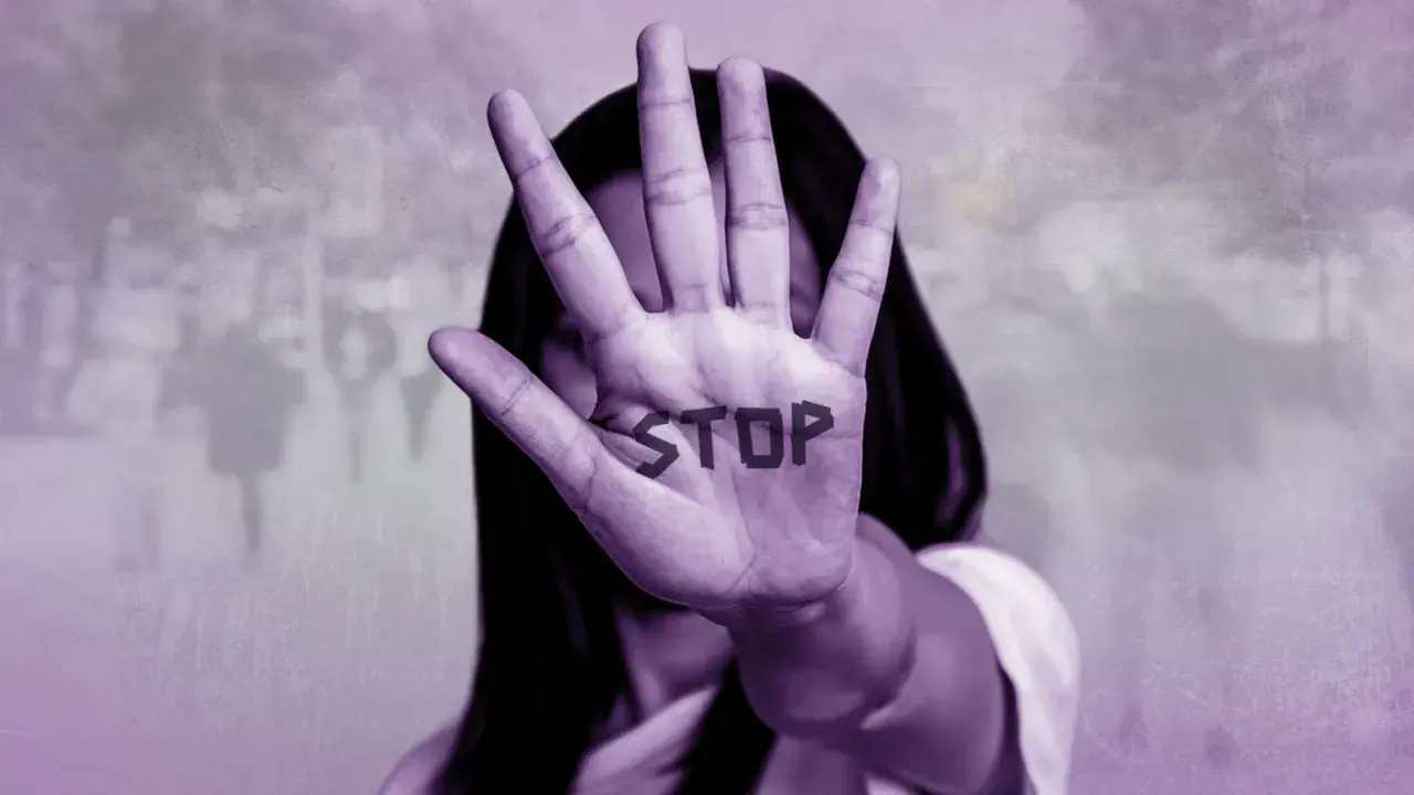 Mano extendida con la palabra "STOP" escrita, simbolizando cómo ayudar a una mujer maltratada.