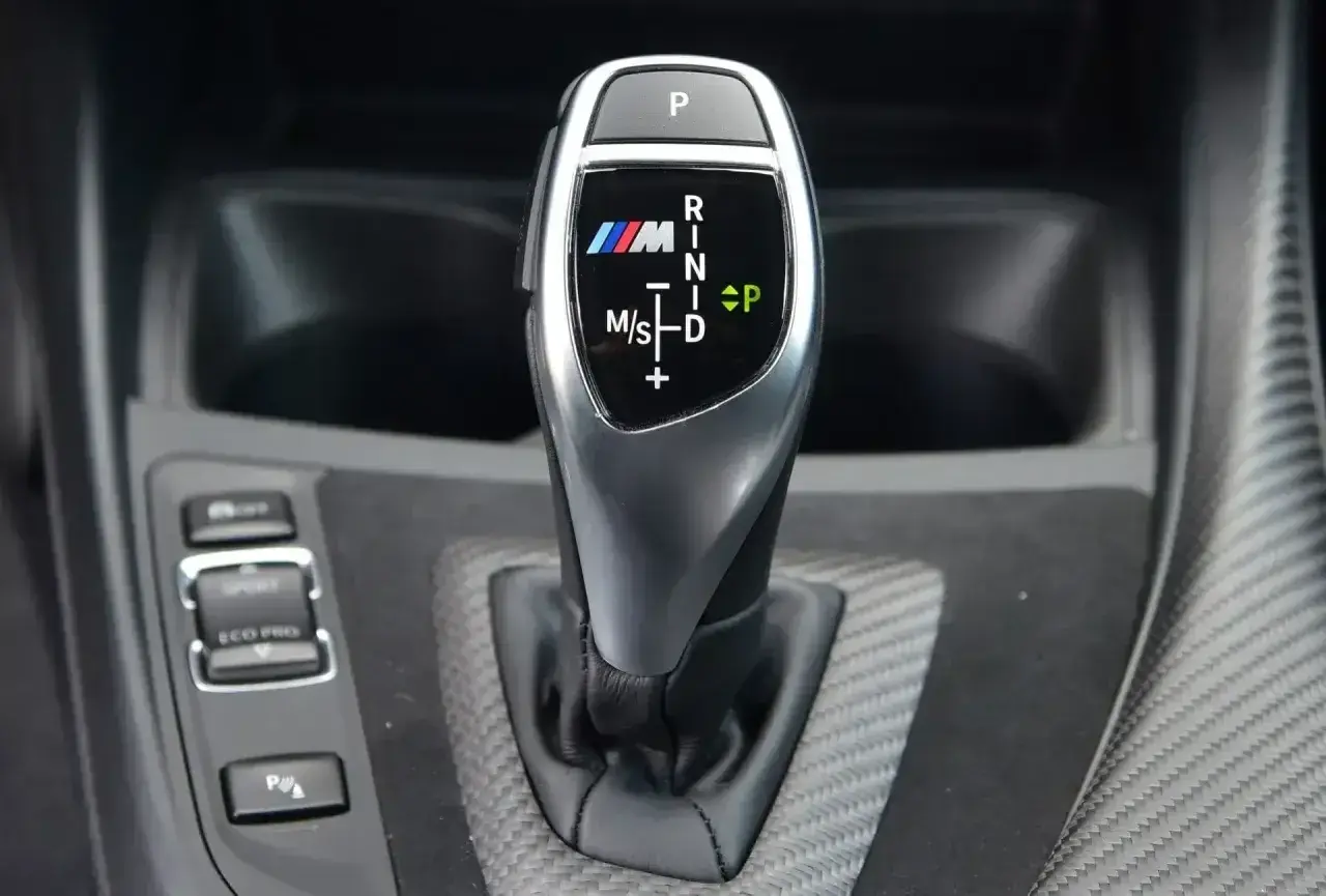 Oznaczenia automatycznej skrzyni biegów BMW M: P, R, N, D, M/S. Wskazują tryby jazdy i pozycje.