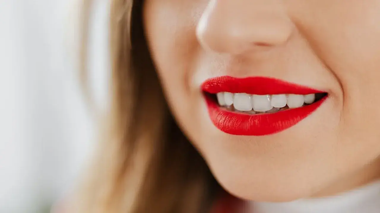 Labios rojos vibrantes y una sonrisa deslumbrante.