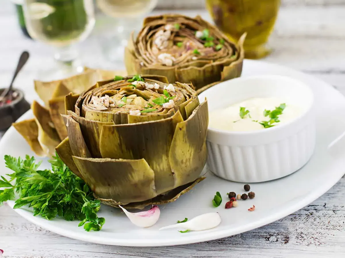 Artichauts entiers, tendres et savoureux, prêts pour la cuisson vapeur. Servis avec une sauce crémeuse et des herbes fraîches.