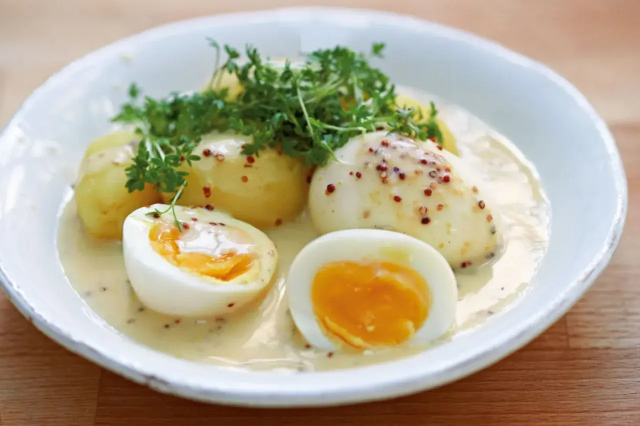 Eier in Senfsauce, ein klassisches Rezept von Mutti, serviert mit Kartoffeln und Kresse.