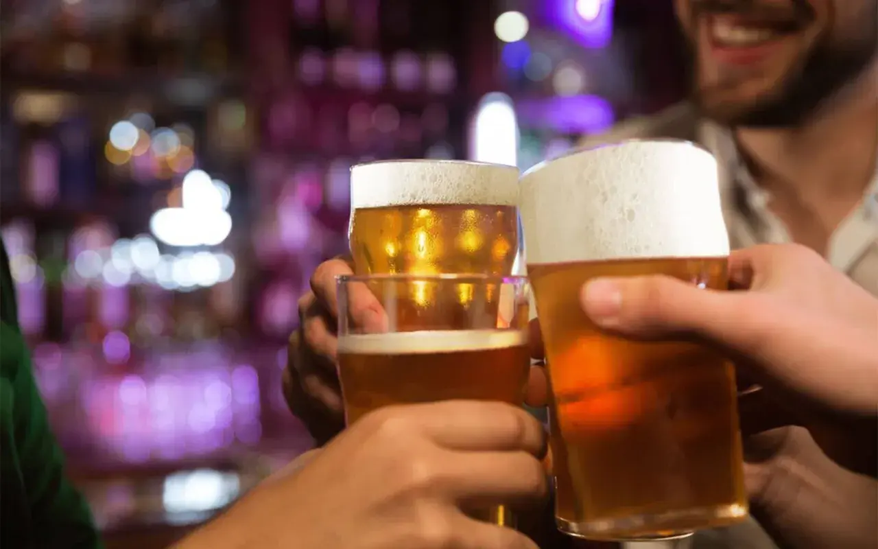 Brindisi con birra in un locale. Forse dopo un bicchiere, la birra fa dormire bene.