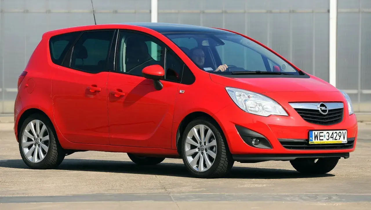 Czerwony Opel Meriva B z czarnym dachem, widziany z przodu z boku.