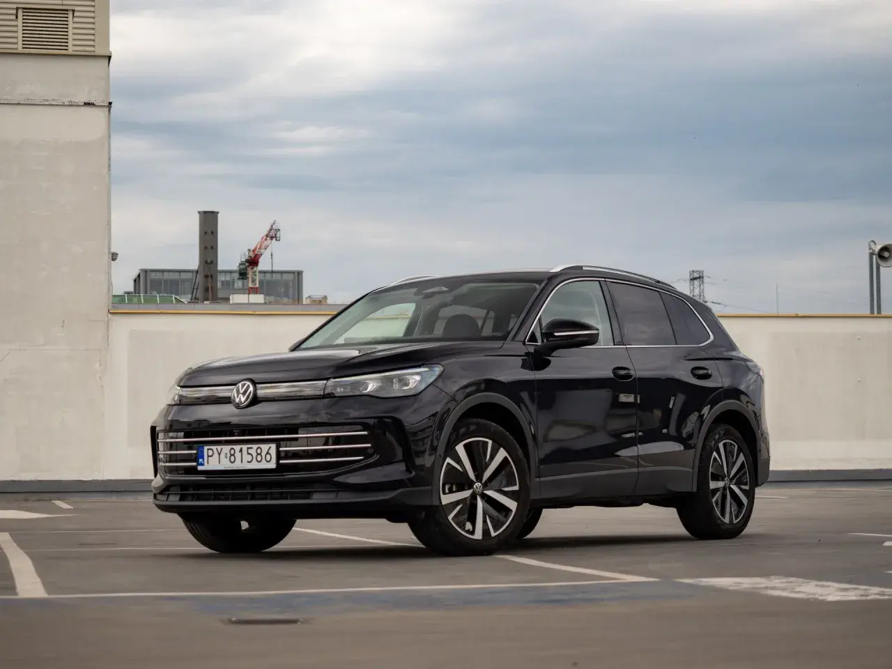 Czarny Volkswagen Tiguan na parkingu. Wiele osób szuka volkswagen tiguan opinie przed zakupem.