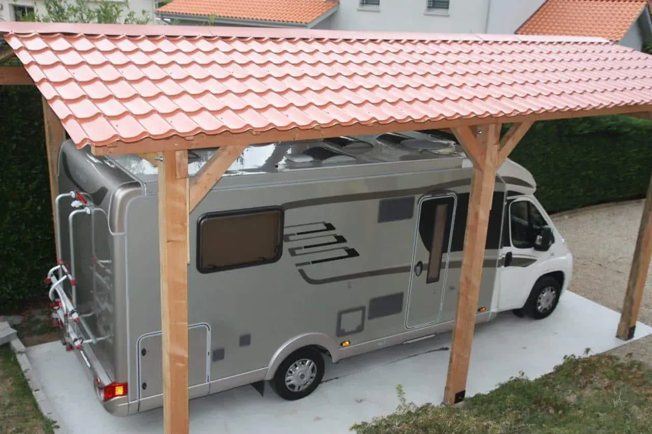 Un camping-car sous un abri simple et économique, parfait pour fabriquer un abris camping-car pas cher.