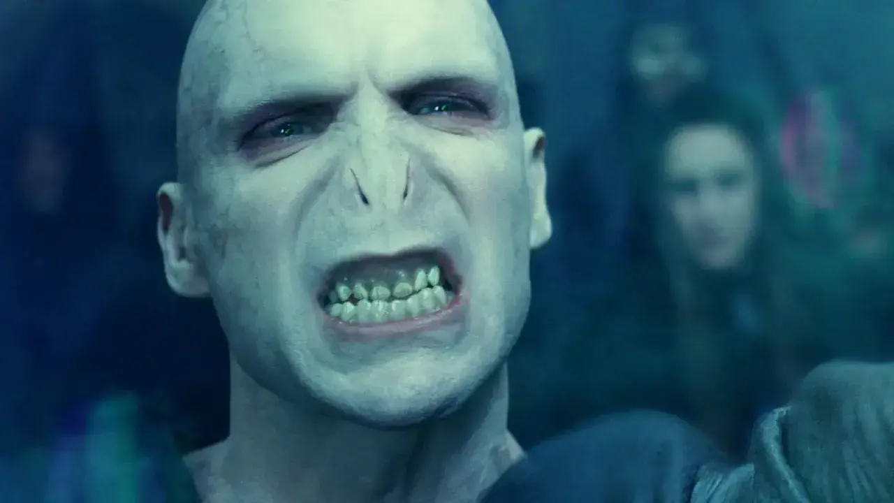 Złowrogi Lord Voldemort, którego grał Ralph Fiennes, z groźnym wyrazem twarzy i zielonymi oczami.
