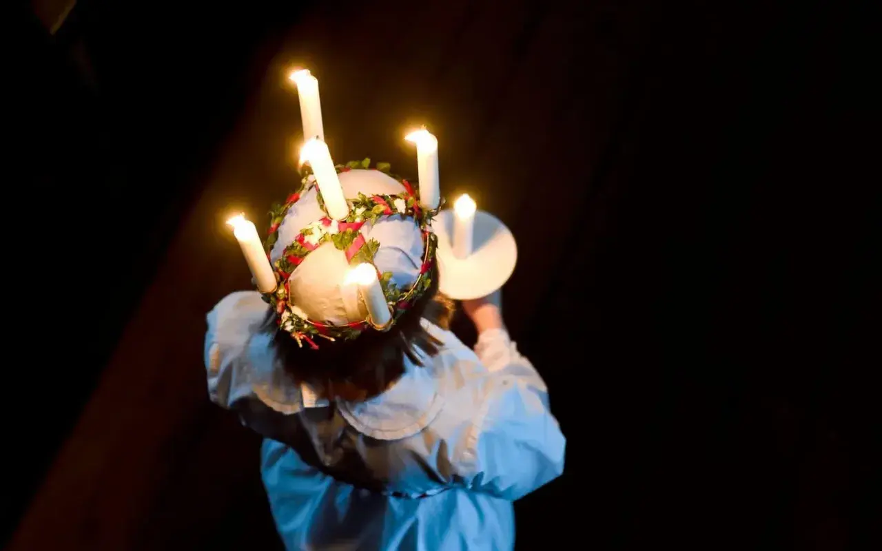 En flicka med ljus i håret, en svensk tradition. Frågan om det är haram att fira jul är komplex och beror på tolkning.