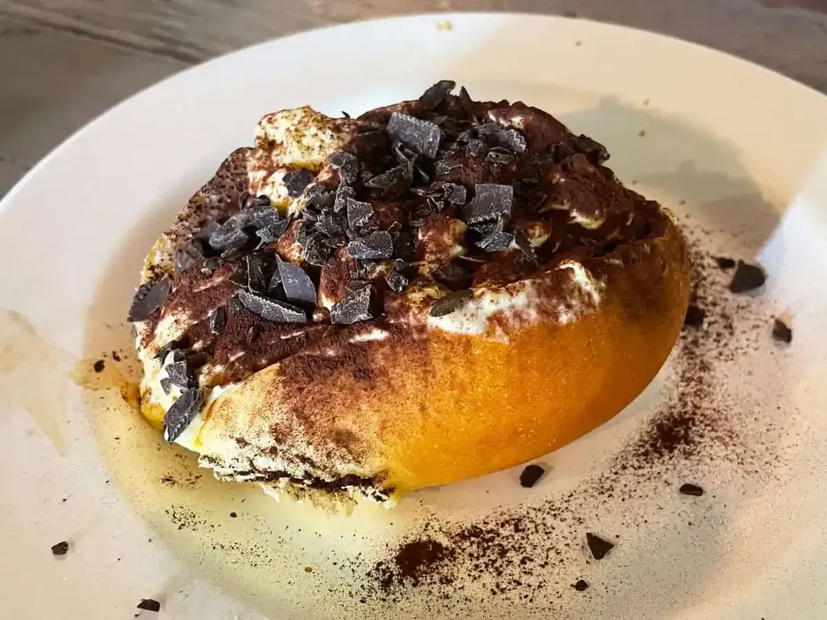 Un dolce al cucchiaio, soffice e cremoso, cosparso di cacao e scaglie di cioccolato. Un assaggio di cosa si mangia a Roma, un'esperienza da non perdere.