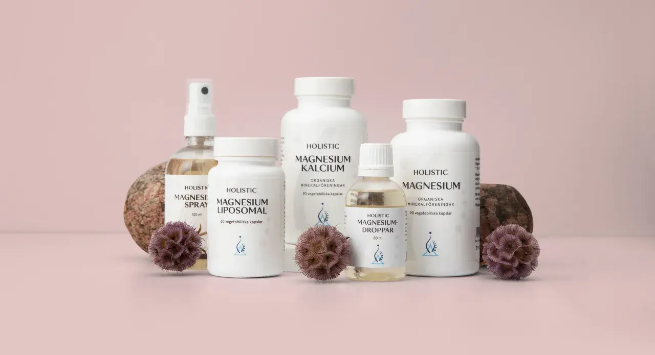 Flera flaskor och burkar med magnesiumtillskott, inklusive magnesium tillskott gravid, står uppradade med stenar och torkade blommor.