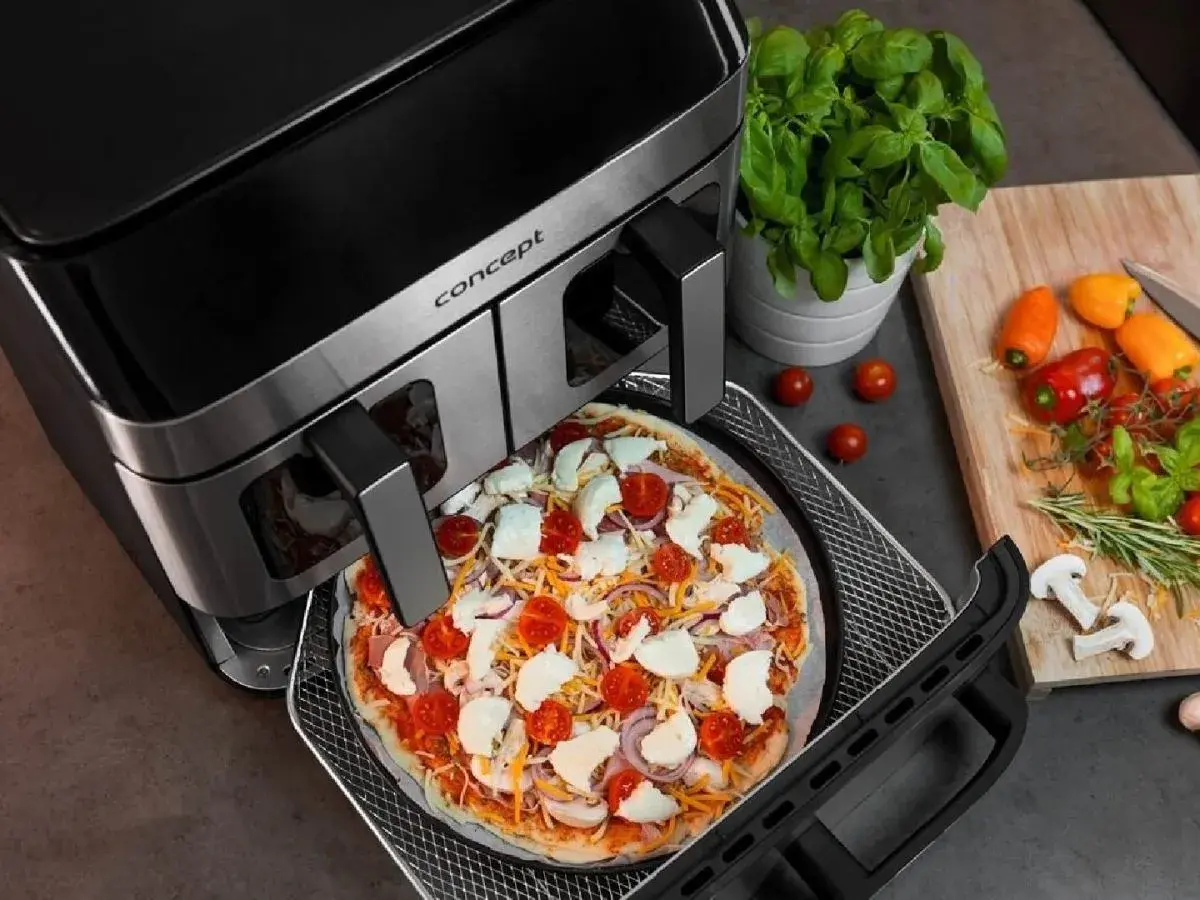 Gotowa do pieczenia pizza w air fryerze. Pyszna, domowa pizza z pomidorami i mozzarellą w zasięgu ręki dzięki nowoczesnemu urządzeniu.