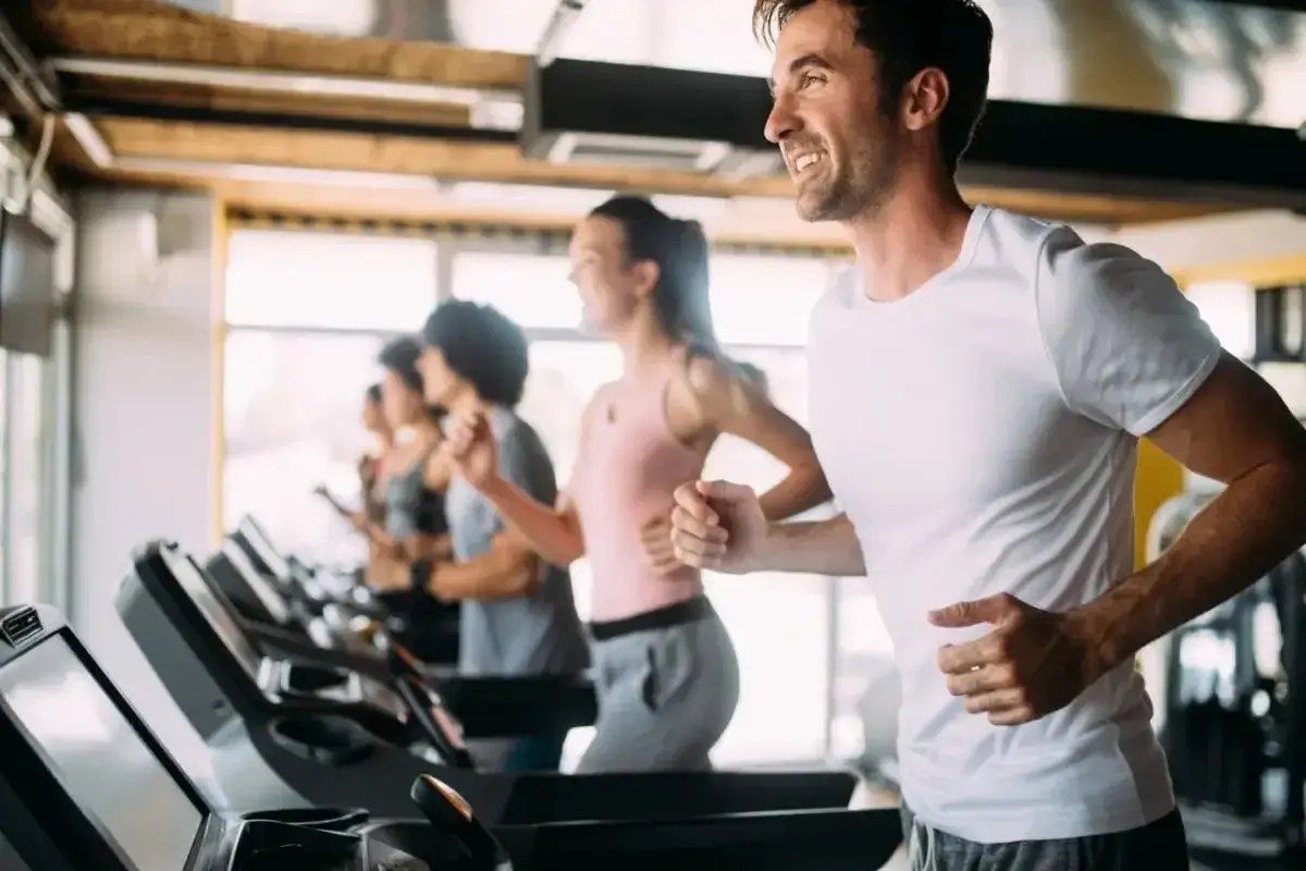 Uomini e donne corrono sui tapis roulant in palestra. Ashvamap a cosa serve? A migliorare la resistenza e la forma fisica.
