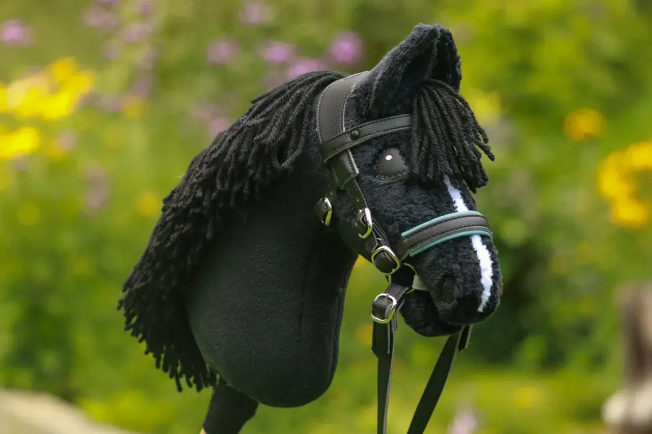 Czarny koń na kiju z czarną grzywą i ozdobnym ogłowiem dla hobby horse.