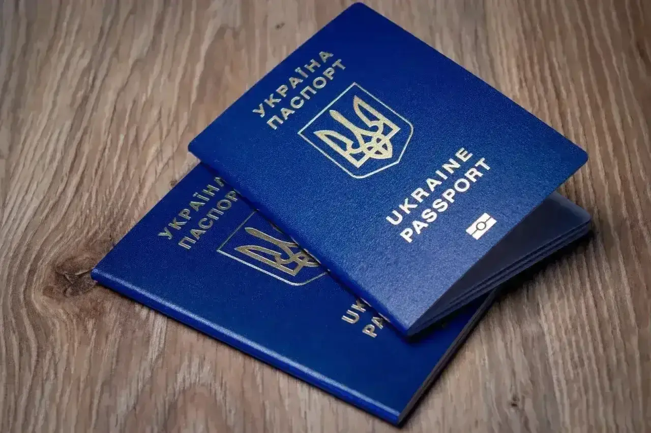 Dwa niebieskie paszporty Ukrainy leżą na drewnianym blacie. Czy wystarczy paszport, czy potrzebny jest dowód na wyjazd do Turcji?