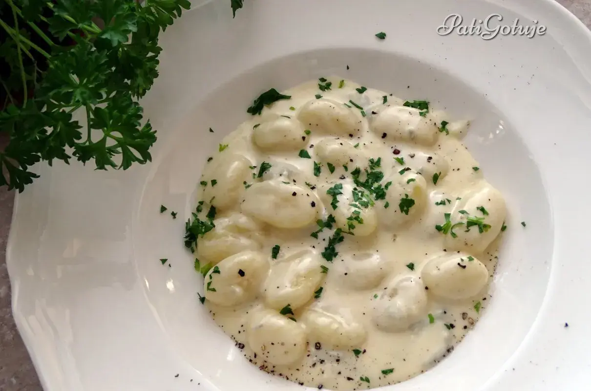 Puszyste gnocchi z gorgonzolą w kremowym sosie, posypane świeżą natką pietruszki. Idealne danie dla miłośników włoskich smaków.