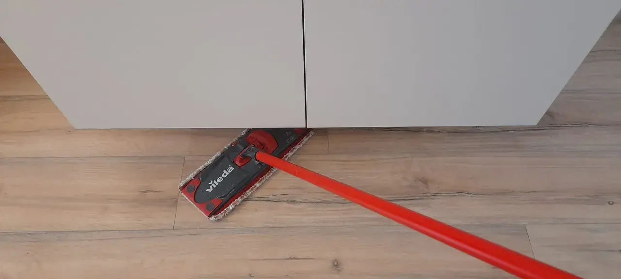 Mocio Vileda rosso pulisce il pavimento in legno, mostrando come smacchiare il legno con facilità.