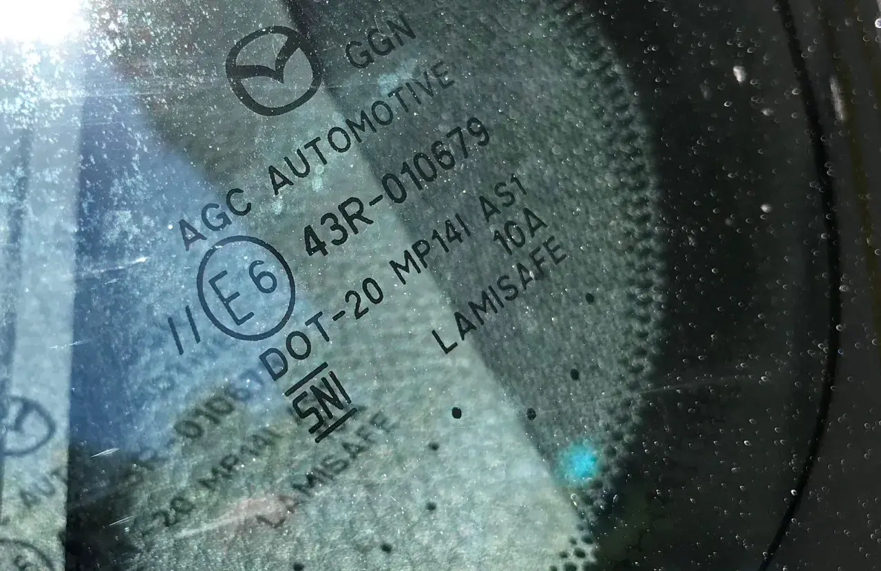 Widoczne oznaczenia na szybach samochodowych: AGC AUTOMOTIVE, E6, 43R-010679, DOT-20, LAMISAFE.