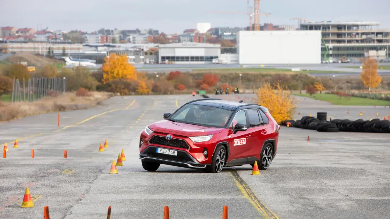 Röd Toyota RAV4 Hybrid genomför ett test på en bana med koner. En bil som testas för att se om det finns något toyota rav4 hybrid problem.