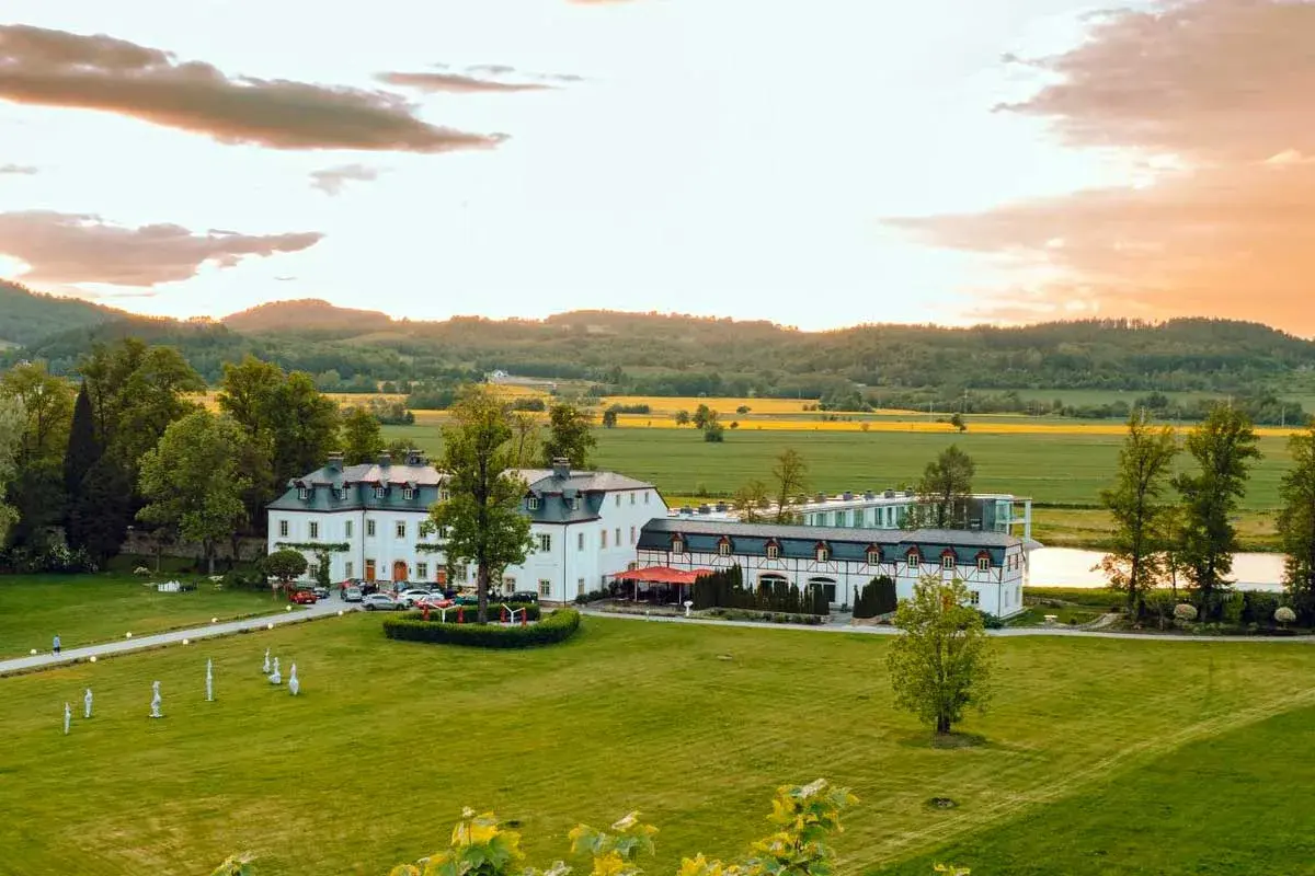 Das Schlosshotel Wernersdorf, ein prachtvolles Anwesen, liegt eingebettet in eine malerische Landschaft mit Feldern und Hügeln.
