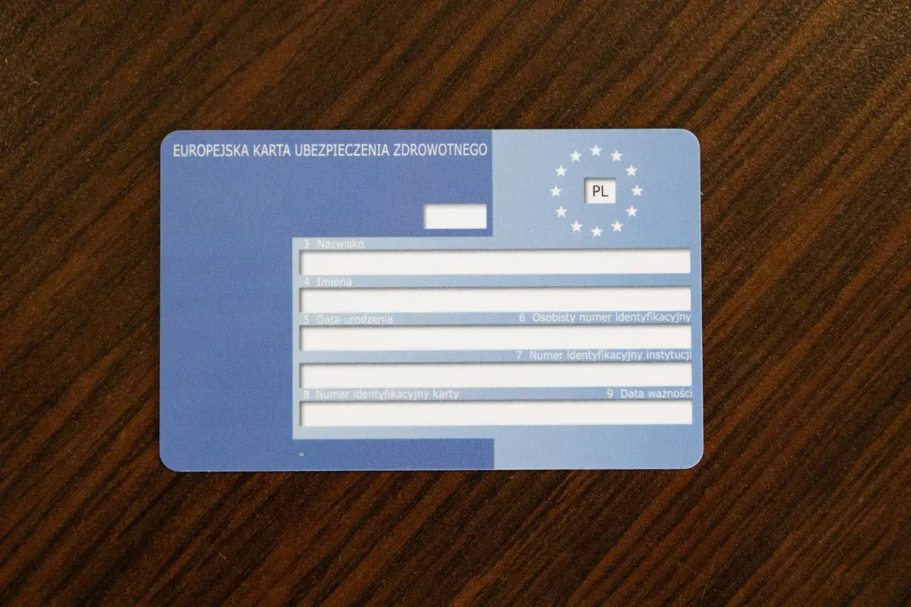 Europejska karta ubezpieczenia zdrowotnego z oznaczeniem PL. Dokument zawiera pola na nazwisko, imiona, datę urodzenia i numery identyfikacyjne.