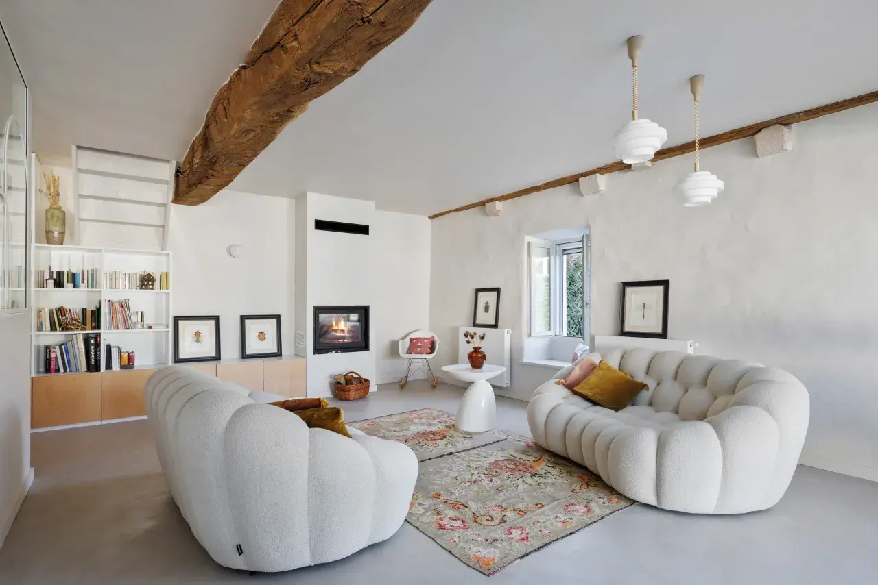 Salon cosy avec cheminée et canapés arrondis. La ventilation appartement est discrète, intégrée au design moderne.