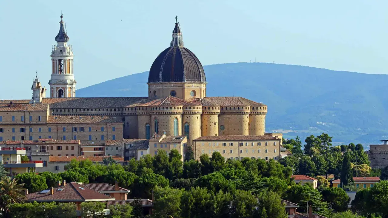 Basilica della Santa Casa a Loreto, vicino Ancona, con la sua imponente cupola e campanile, circondata da verde.