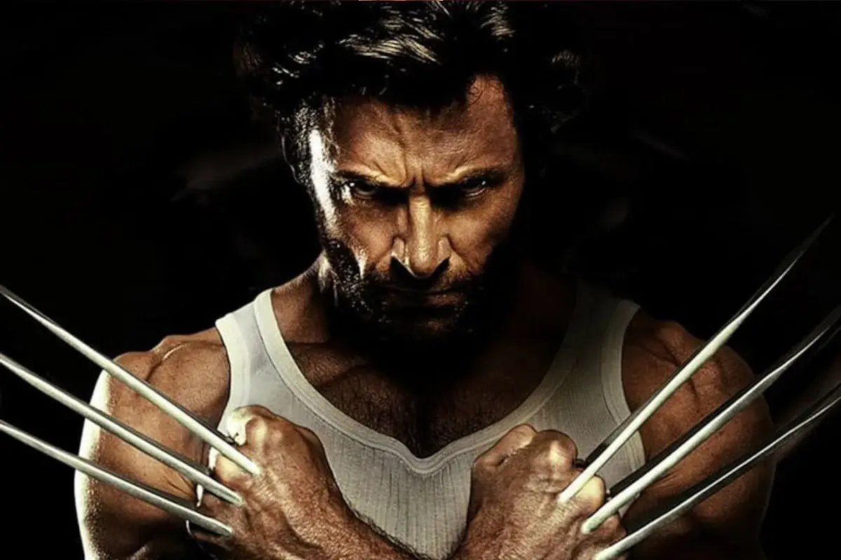 Wolverine po polsku, z pazurami wysuniętymi, w białej podkoszulce, patrzy groźnie.