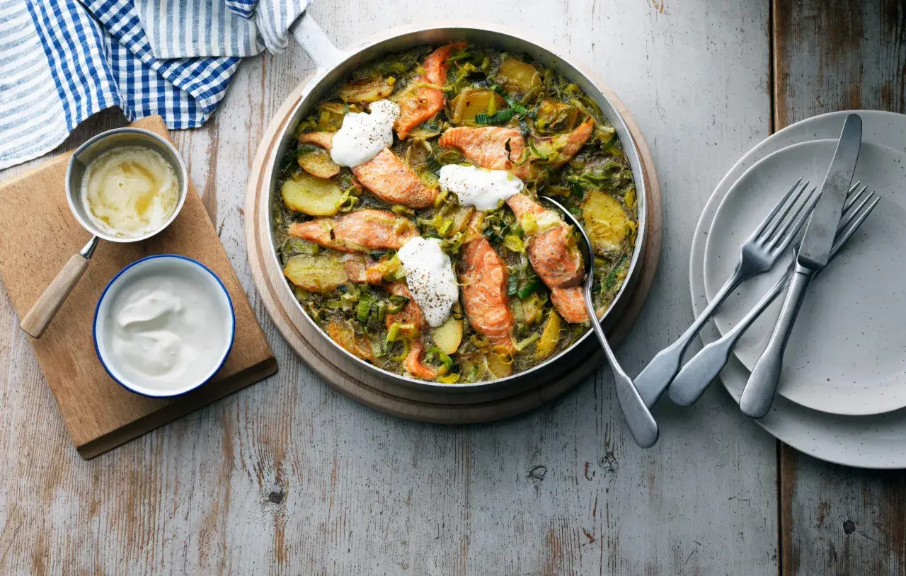 En härlig laxrätt med potatis och purjolök, toppad med en klick gräddfil. Ett perfekt lax recept för en mysig middag.