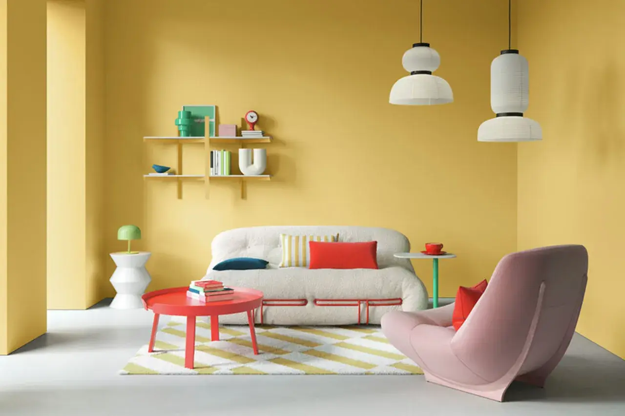 Ein Wohnzimmer mit gelben Wänden, das durch kreative Wandgestaltung mit Farbe und modernen Möbeln besticht.