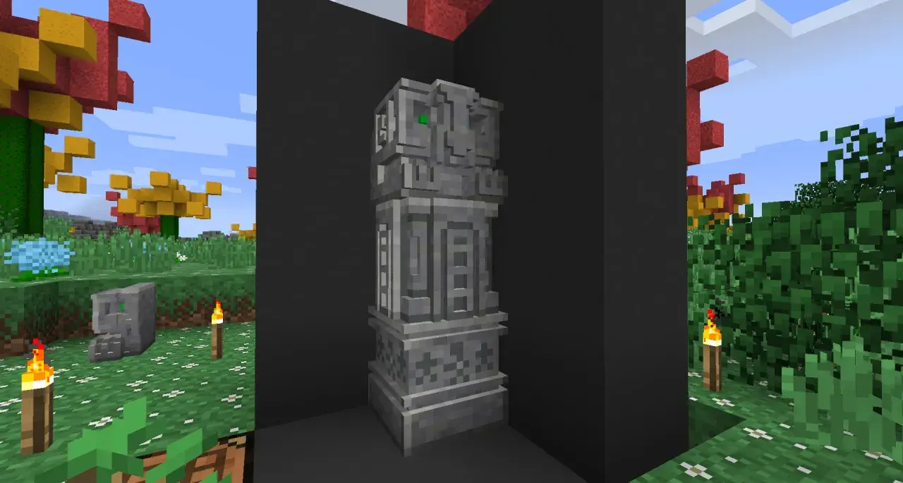 Kamienny monument z zielonymi oczami, jakby wyrzeźbiony dłutem i dłutkami. W tle jesienne drzewa i trawa.