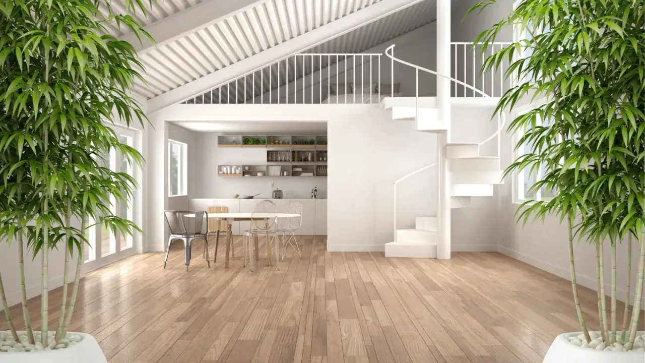Interno moderno con cucina, tavolo e sedie. Una scala a chiocciola bianca porta a un soppalco a vista. Bambù verde incornicia la scena.