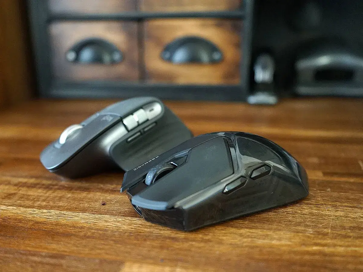 Dos ratones, periféricos de entrada esenciales, descansan sobre una mesa de madera.