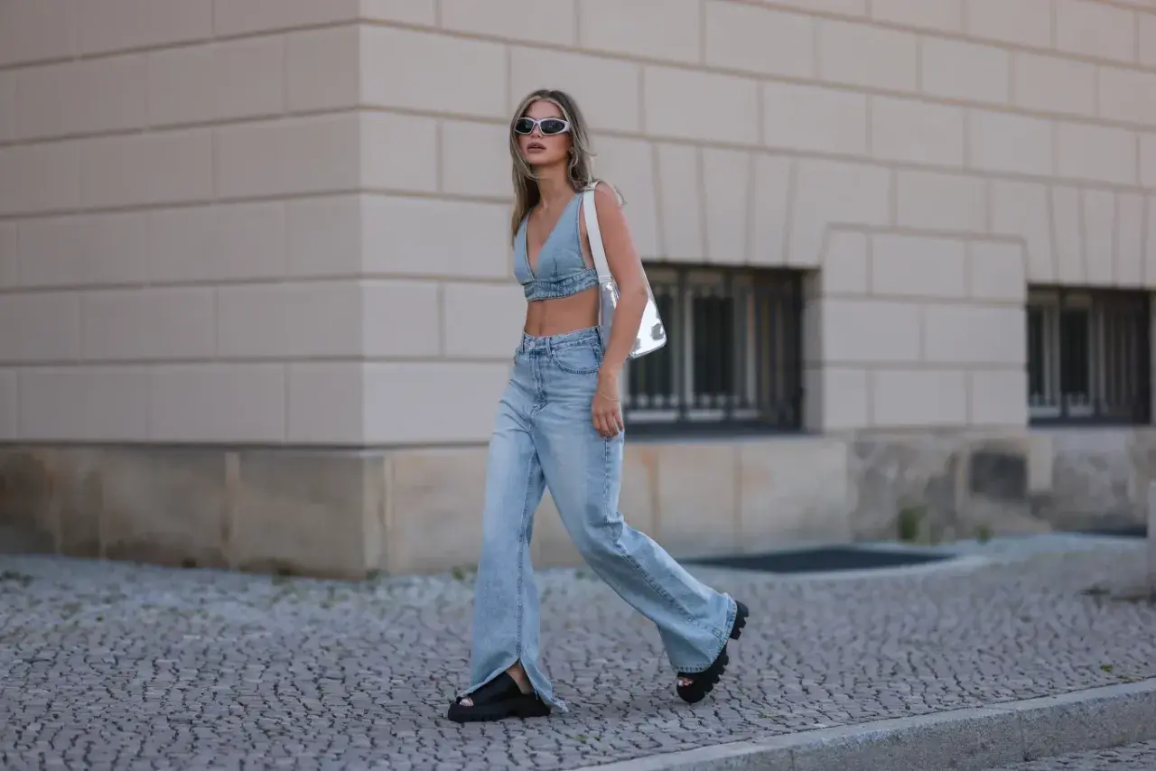 Stylowa kobieta w jeansach bootcut z rozcięciami i denimowym topie, prezentująca letnią modę.