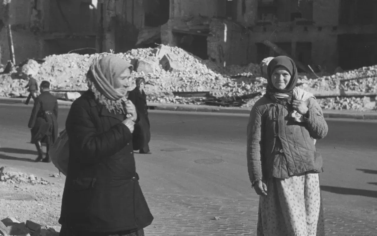 Zwei Frauen stehen in Kiew 1941 vor Trümmern. Die eine trägt einen Schal, die andere eine Steppjacke.