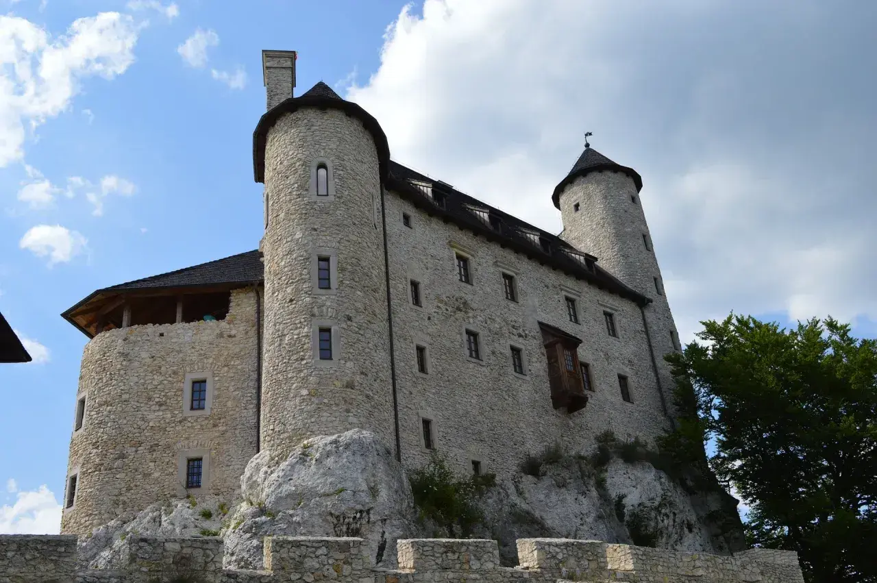 Kamienny zamek na skale, jedna z głównych atrakcji Bobolic, z wieżami i murami obronnymi.