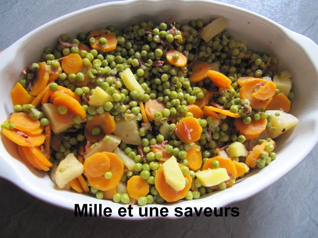 Jardinière de légumes colorée, avec des petits pois, des rondelles de carottes et des morceaux de pommes de terre, prête à être dégustée.