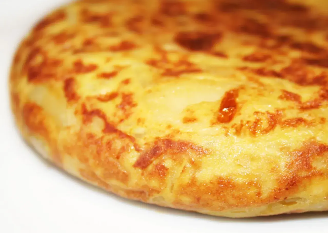 Une tortilla espagnole au four, dorée et appétissante, prête à être dégustée. Parfait pour une recette facile et savoureuse.