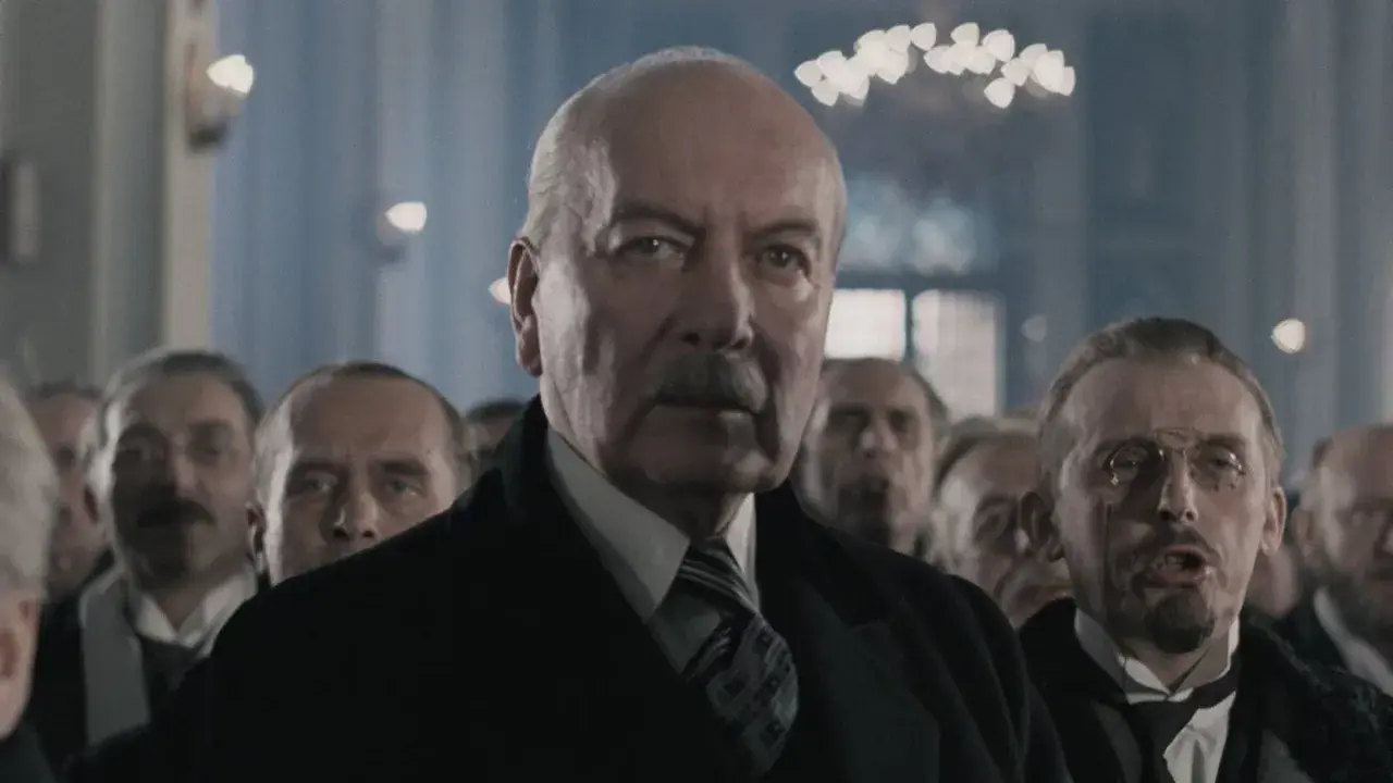 Starszy mężczyzna z wąsami i grupą ludzi w tle. Czy to scena z filmu, która ukazuje największe błędy historyczne w polskich filmach, o których milczą twórcy?