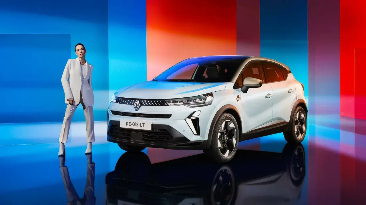 Eleganza e innovazione: una donna in tailleur bianco accanto alla nuova Captur GPL, con uno sfondo che sfuma dal blu al rosso.