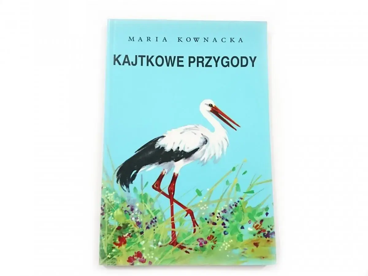 Okładka książki "Kajtkowe przygody" Marii Kownackiej z bocianem na tle nieba i łąki.