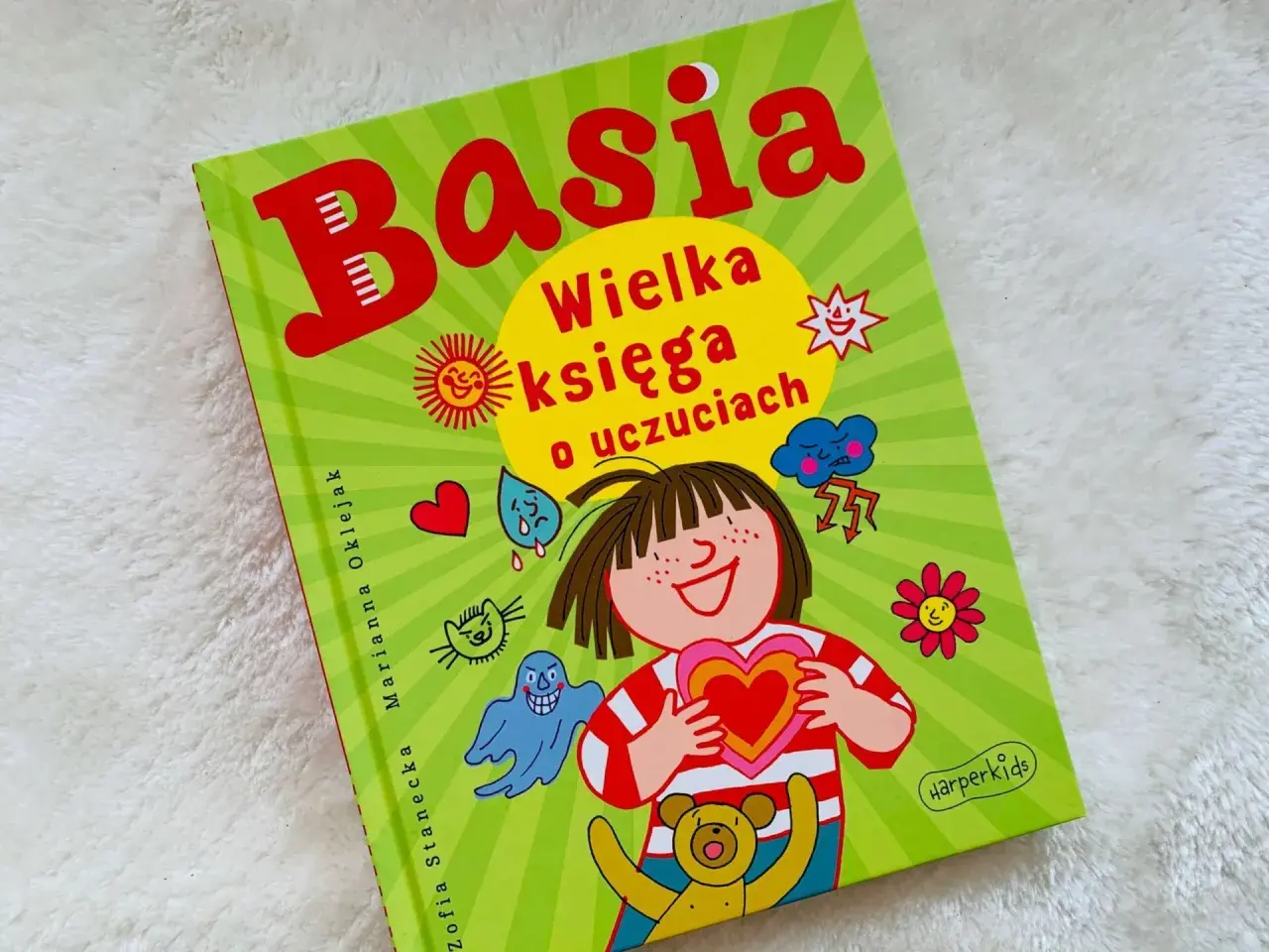 Okładka książki "Basia. Wielka księga o uczuciach" z ilustracjami przedstawiającymi różne emocje i postacie.